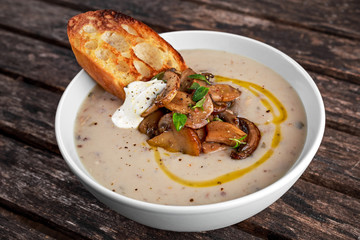 Mushroom soup with crouton and sour cream, olive oil