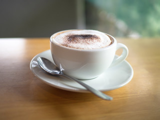 Hot capuccino white cup and spoon on wood table