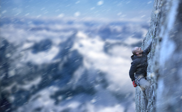 young white male climbing rock in winter in extreme conditions 