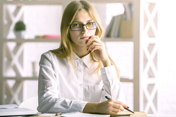 Attractive woman writing in notepad