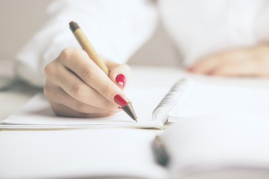 Businesswoman writing in notepad