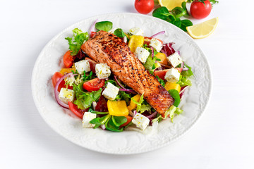 Fried Salmon steak with fresh vegetables salad, feta cheese. concept healthy food.