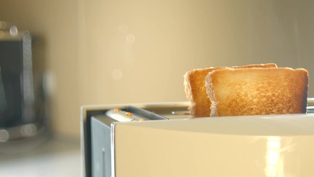 Roasted toast bread popping up from toaster machine with smoke. 4K ultra high definition video. UHD 3840X2160