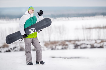 Fototapeta na wymiar man standng on the snow with snowboard