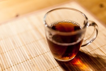 Glass of tea on light brown background