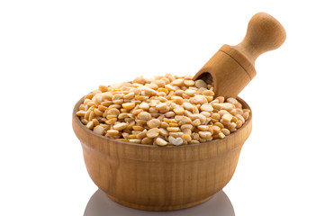 Yellow peas in a wooden bowl with a spatula