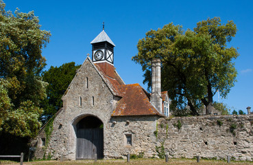 Fototapeta premium Ancient English Abbey walls with Its Gatehouse entrance and Tudor style clock tower in Beaulieu in Hampshire England