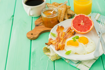 Summer breakfast - eggs, bacon, toast, jam, coffee, juice