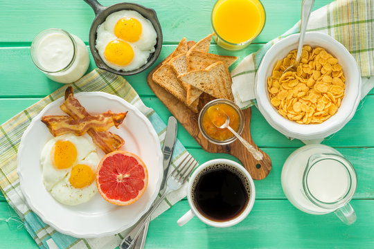 Summer breakfast - eggs, bacon, toast, jam, coffee, juice