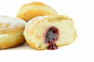 Close up of a cut jam filled doughnut on a white background