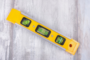 Spirit level tool isolated on reclaimed wood background