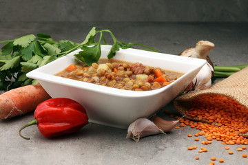 Lentil soup with pita bread in a bowl on a wooden background