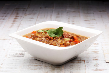 Lentil soup with pita bread in a bowl on a wooden background