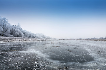 Winter landscape with frozen pond.