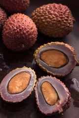 Three slices of fruit, lychee and several in the peel.
