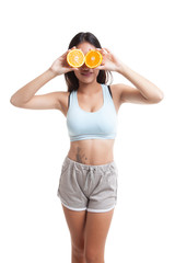 Beautiful Asian healthy girl with orange fruit over her eyes.