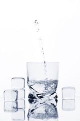 Glass with water, splash, and ice cubes