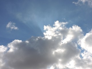 Sunshines coming from behind puffy clouds