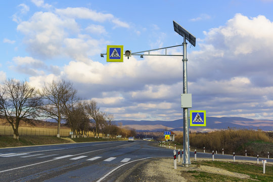 Traffic light complex solar and sign "Pedestrian crossing" on a country road