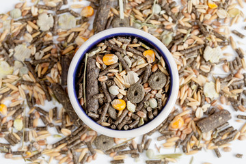 dry food for rodents in bowl white background top view