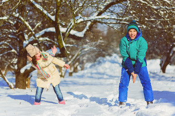 Children play in snowy forest. Toddler kids outdoors in winter. Friends playing in snow. Christmas vacation for family