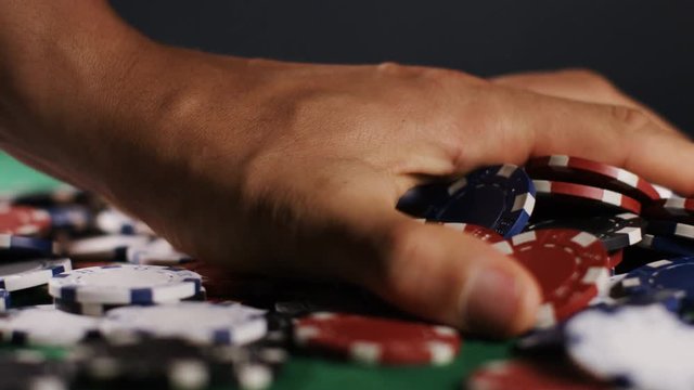 4K Hand collecting winnings in a game of poker, in slow motion