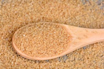 Beige sugar in a wooden spoon