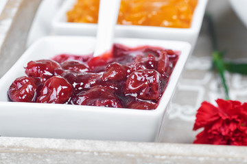 Fruit jams in white bowls on a wooden tray