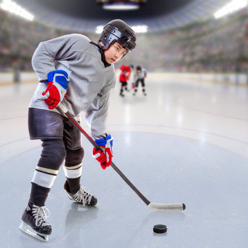 Junior Ice Hockey Player in Crowded Arena. Focus on player and shallow depth of field on background.