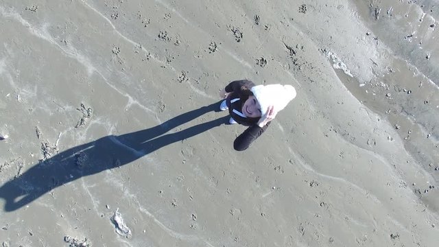 4k aerial vide of a woman waving to the camera