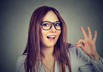 Obraz premium Successful teenager. Nerdy funny woman showing ok sign