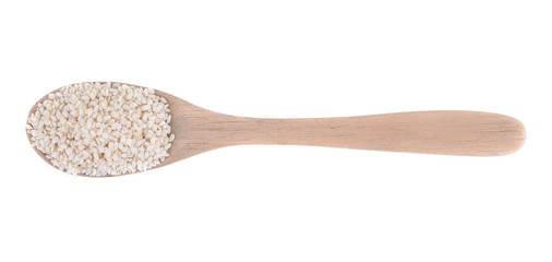 Wooden spoon with sesame seeds on a white background