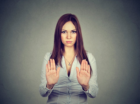 Angry displeased woman raising hands up to say no, stop