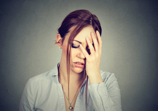 sad woman with worried stressed face expression looking down