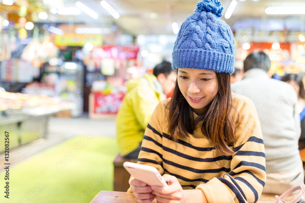 Sticker Woman using cellphone at indoor fish market