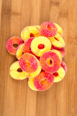 Peach flavored gummy candy isolated on a wood background