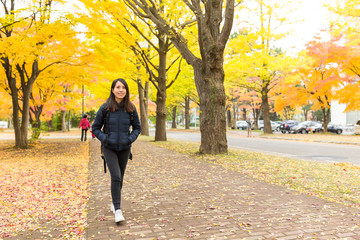 Woman walking at outdoor with gingko tree plant
