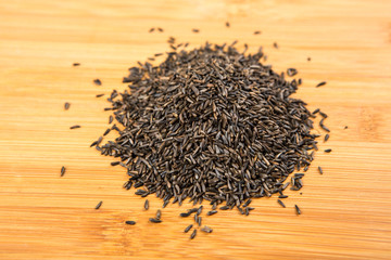 Pile of thistle seed isolated on a wood background