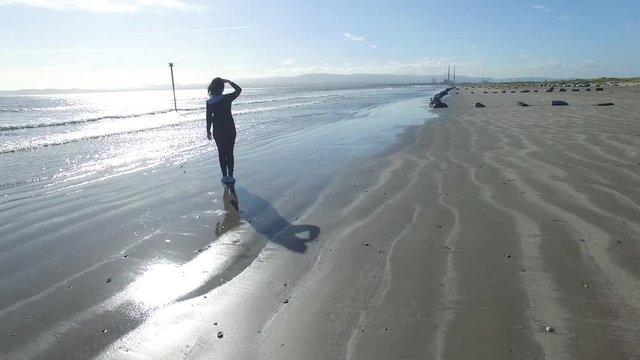 4k aerial footage of a girl looking at the sea