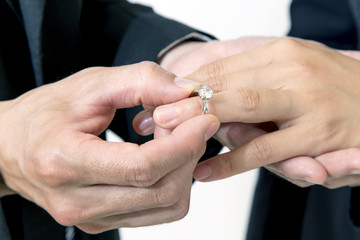 恋人に婚約指輪をはめる手元のアップ