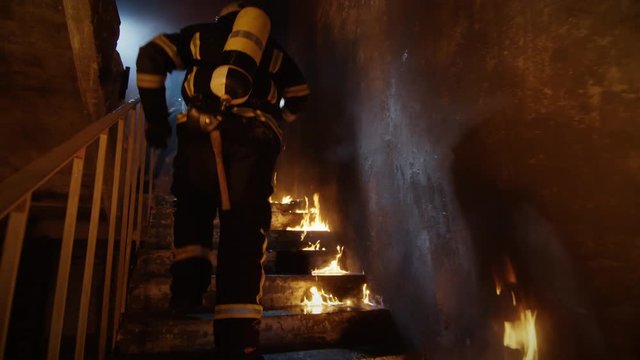 Two Firefighters Passing Through Door and Running Upstars to Safe People. Stairs are Openly On Fire. Shot on RED EPIC (uhd).