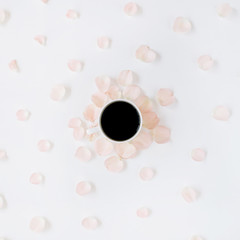 Coffee cup and pink roses petals pattern. Flat lay, top view