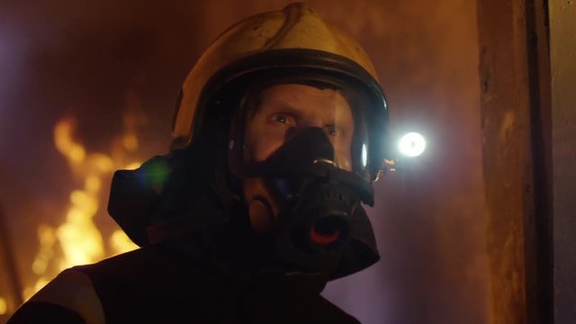 Building is on Fire. Brave Fireman Slowly Enter's the Room while Looking Around. Tongues of Flame are Licking Walls of the House.  Shot on RED EPIC (uhd).