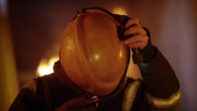  Building is on Fire. Brave Fully Equipped Firefighters Takes off His Helmet. Open Flames in the Background. Slow Motion. Shot on RED EPIC (uhd).