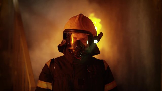 Portrait of a Brave Firefighter Standing in a Burning Building. Raging Fire in the Background.  Shot on RED EPIC (uhd).