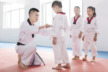 Young instructor teaching children Tae Kwon Do