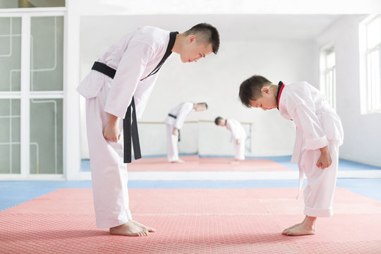 Young instructor teaching boy Tae Kwon Do