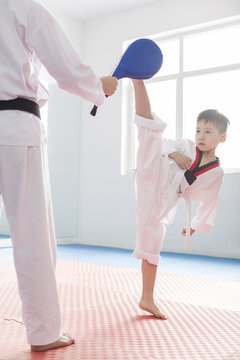 Young instructor teaching boy Tae Kwon Do
