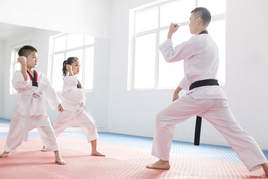 Young instructor teaching children Tae Kwon Do