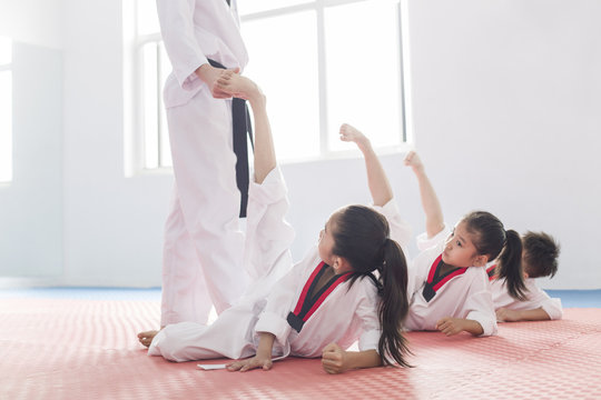 Young instructor teaching children Tae Kwon Do